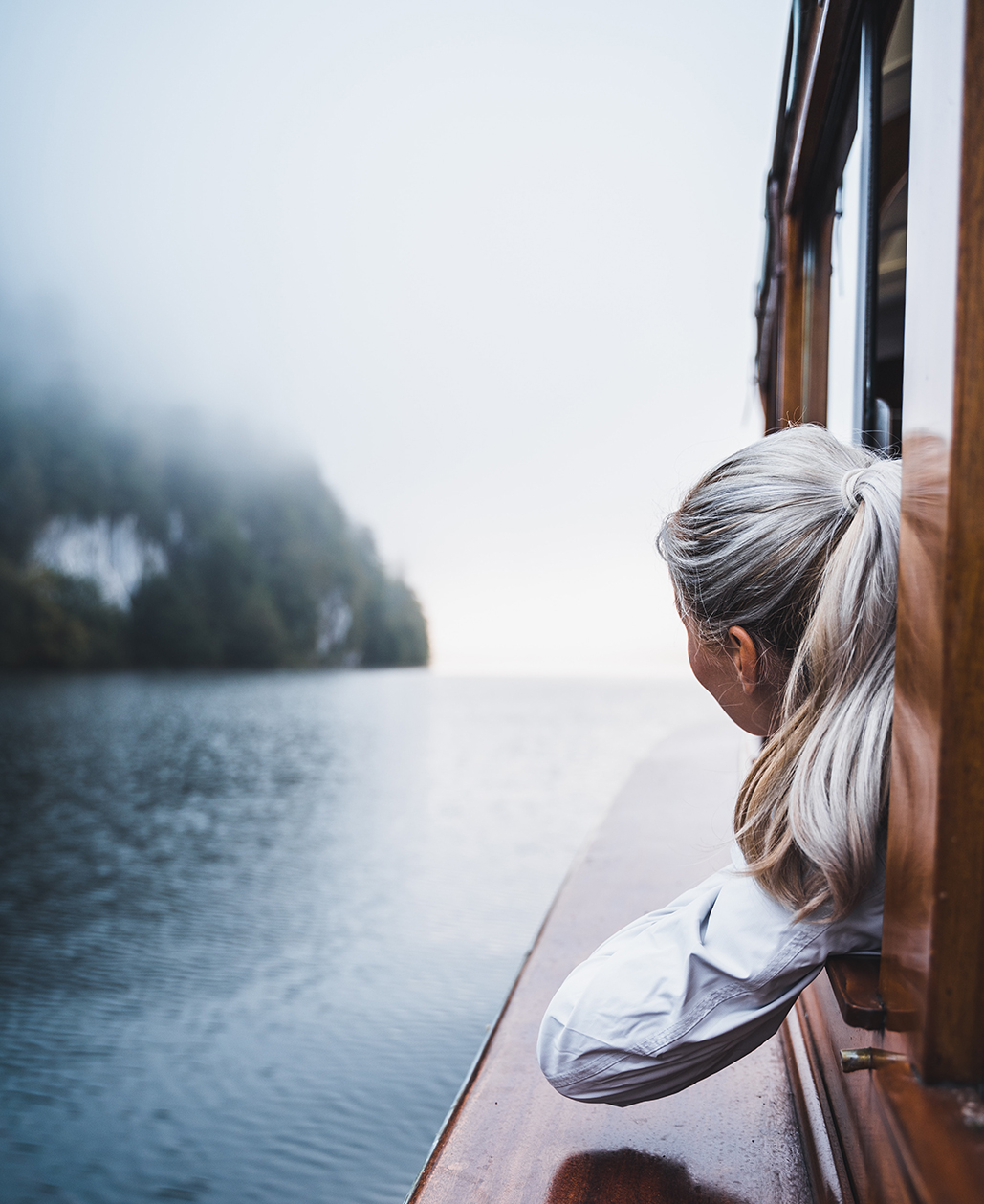 woman in white shirt sitting on brown wooden boat during daytime