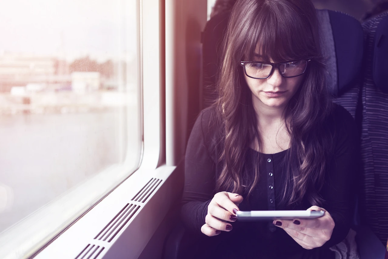 Young woman using tablet pc in- train