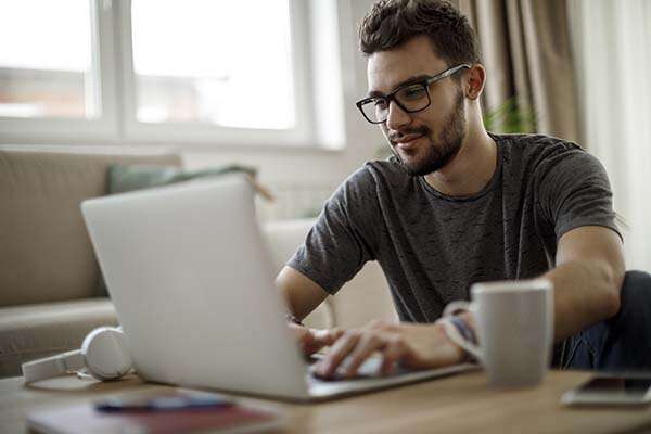 Teenage boy using laptop at home