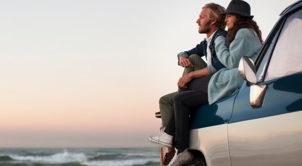 couple-sitting-on-truck-looking-at-ocean-view