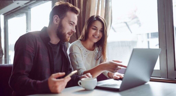 Smilingcouple drinkingcoffee and making video conference