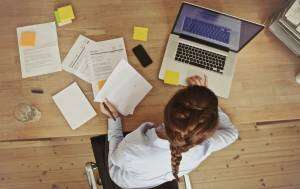 Businesswoman-working-at-her-office-desk-with-documents-and-laptop-1