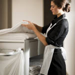 Maid at work cleaning hotel room