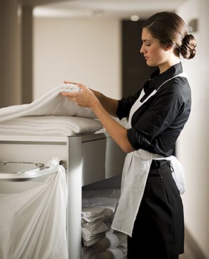 Maid at work cleaning hotel room