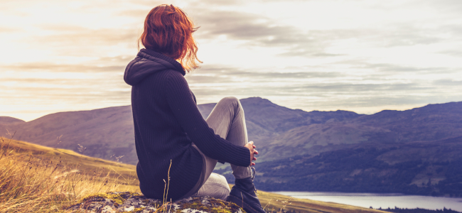 Woman admiring sunset from mountain top