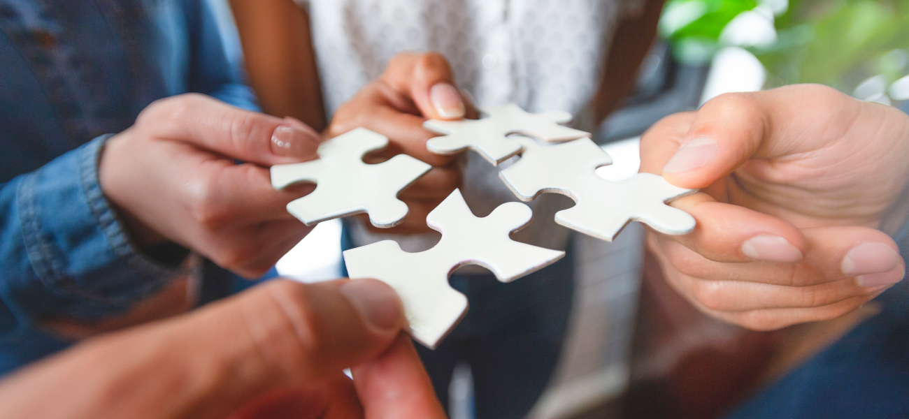 Group of business people holding a jigsaw puzzle pieces.