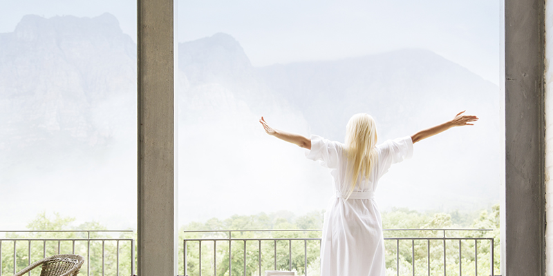 Woman in bathrobe overlooking landscape